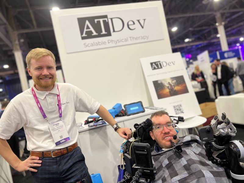 Two men present their ATDev kiosk at a conference